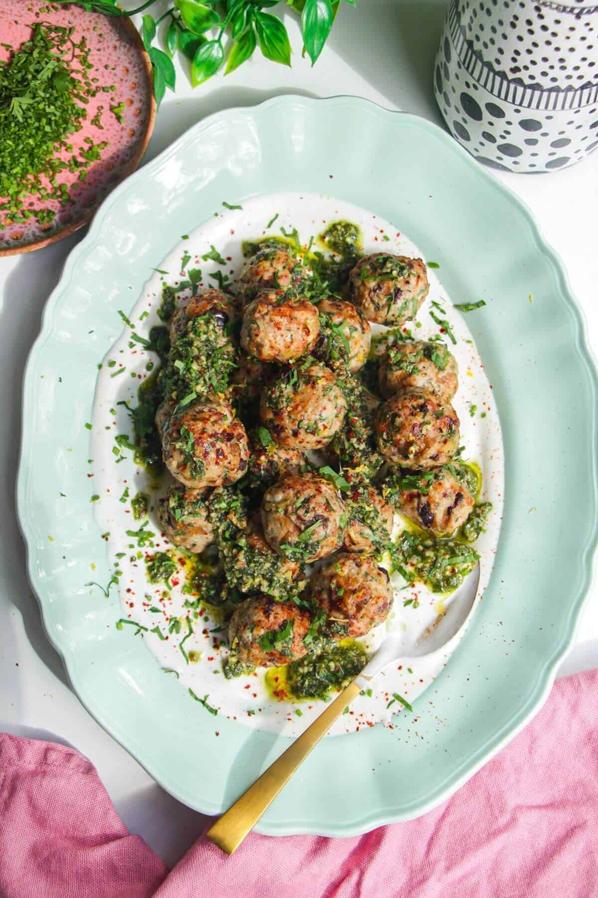 Lemony chicken meatballs on whipped feta, with a spoon.
