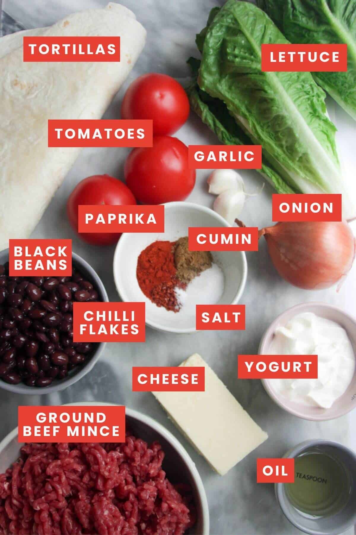 Ingredients for crispy taco burrito bowls laid out on a grey marble background and labelled.