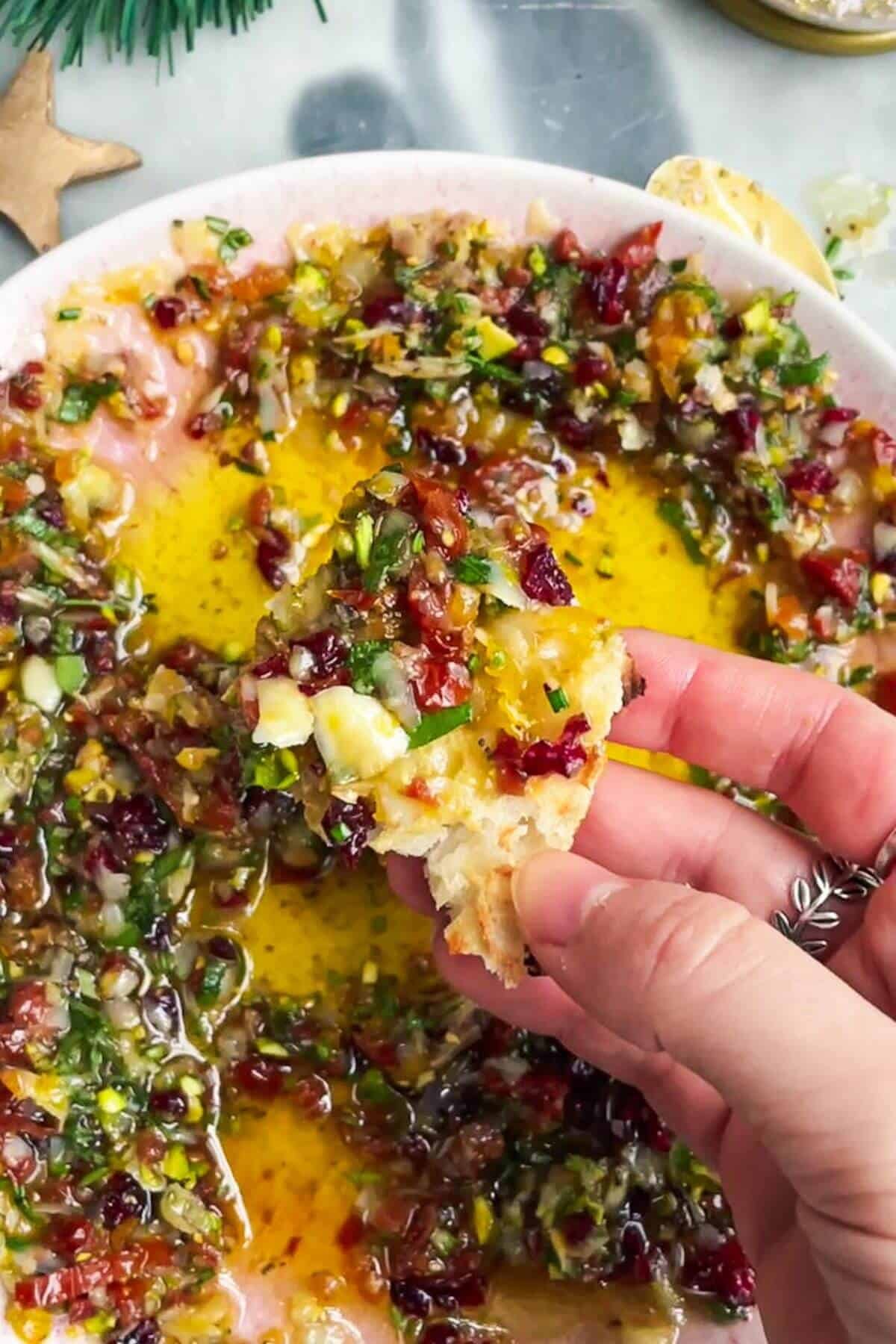 Holding bread with dipping oil on it.