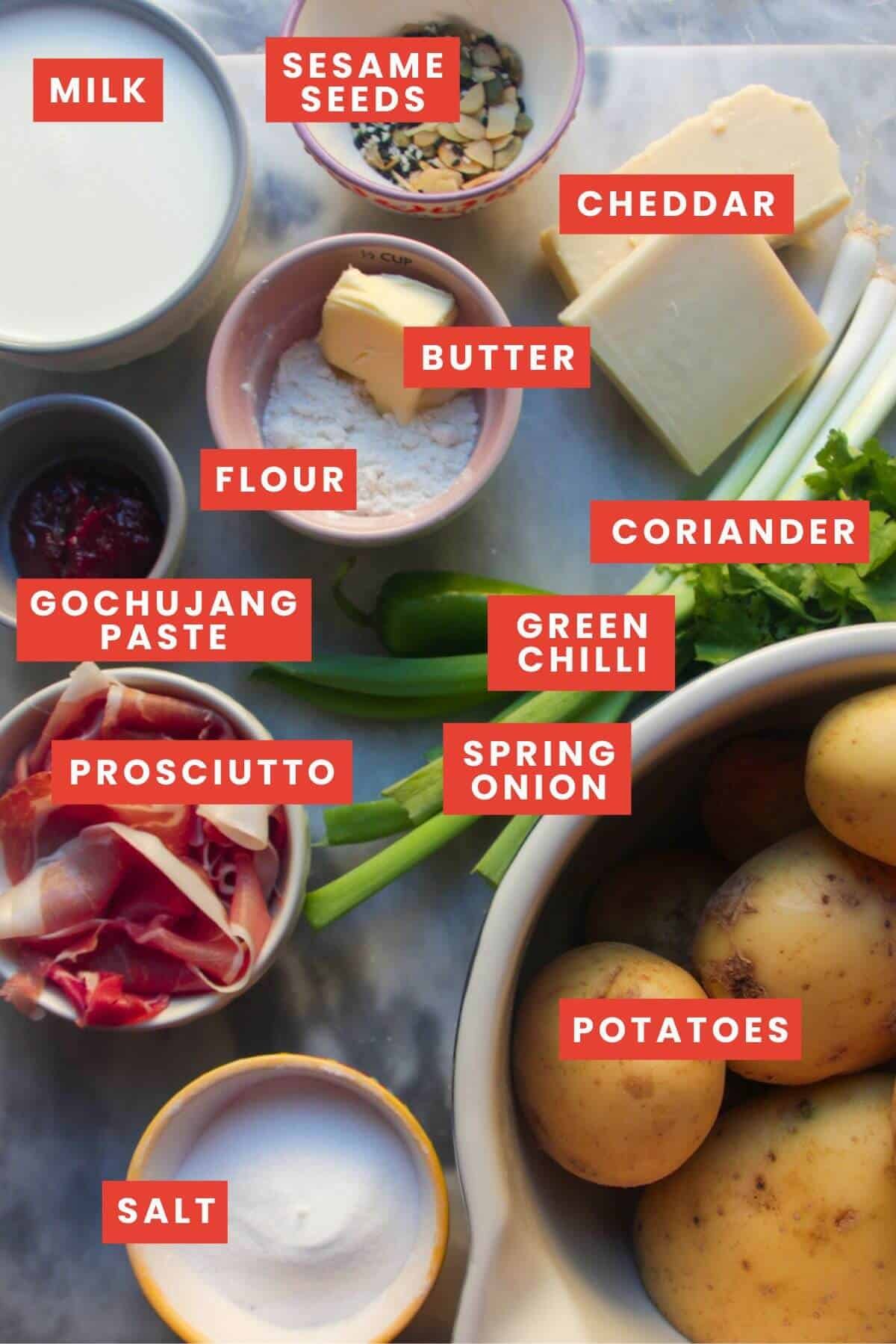 Ingredients for cheesy loaded wedges laid out on a grey marble background and labelled.
