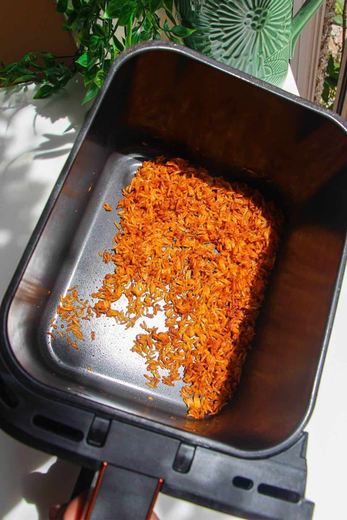 Crispy rice in air fryer basket.