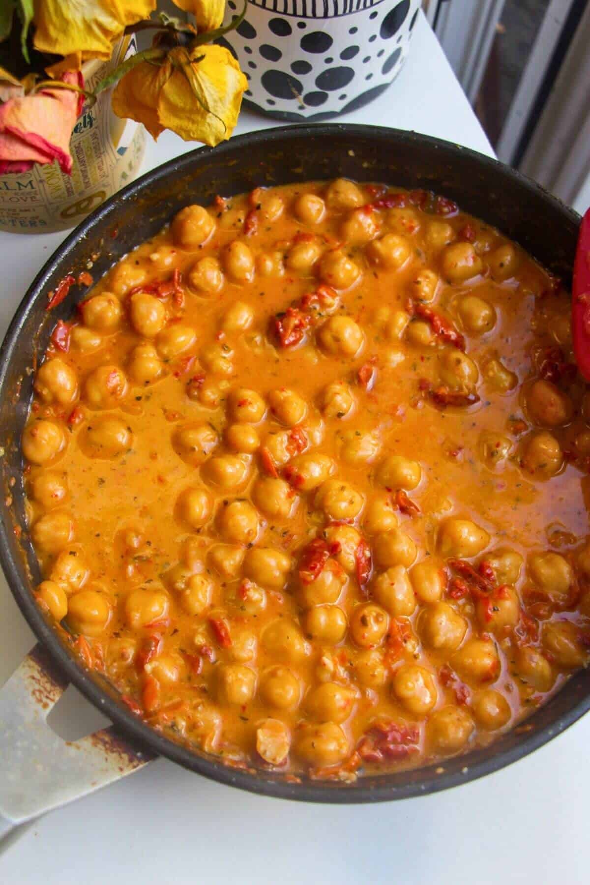 Chickpeas simmering in a creamy sundried tomato sauce.