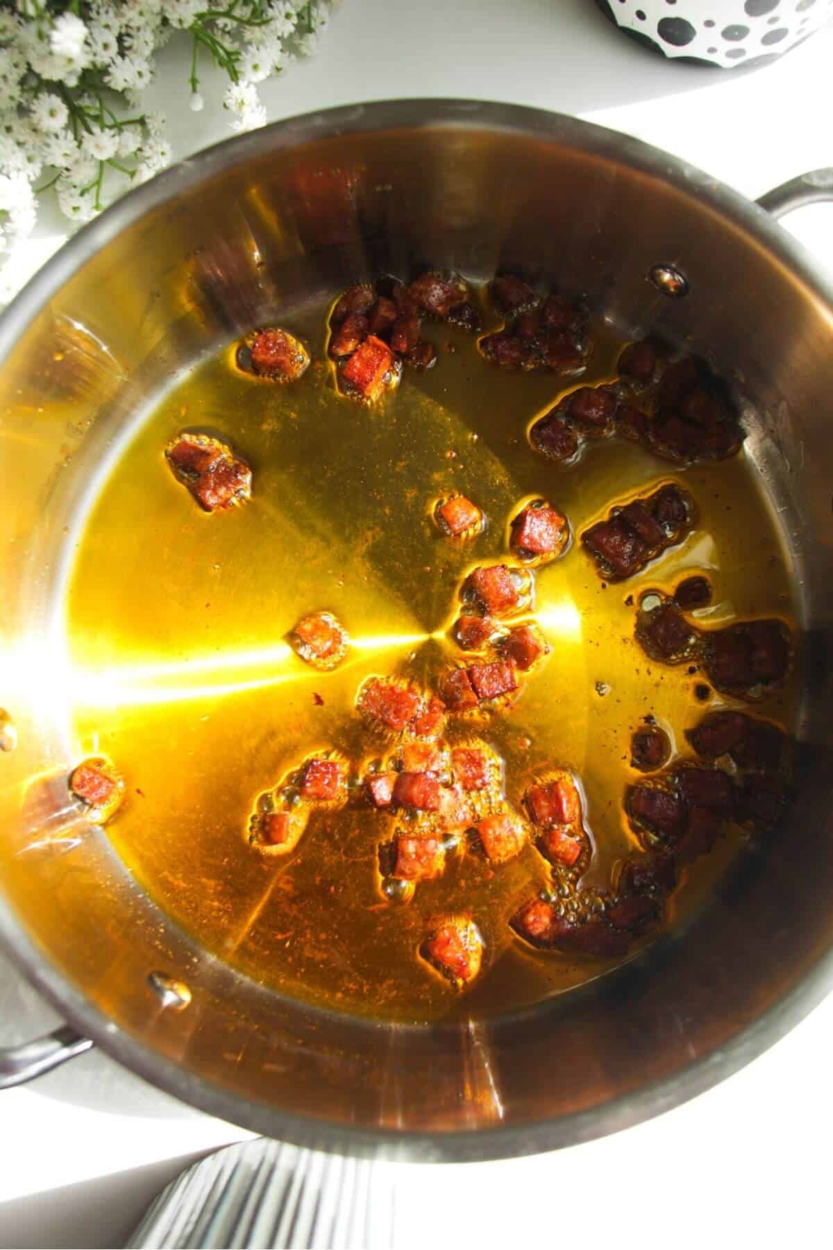 Crispy chorizo in a large stainless steel pan.