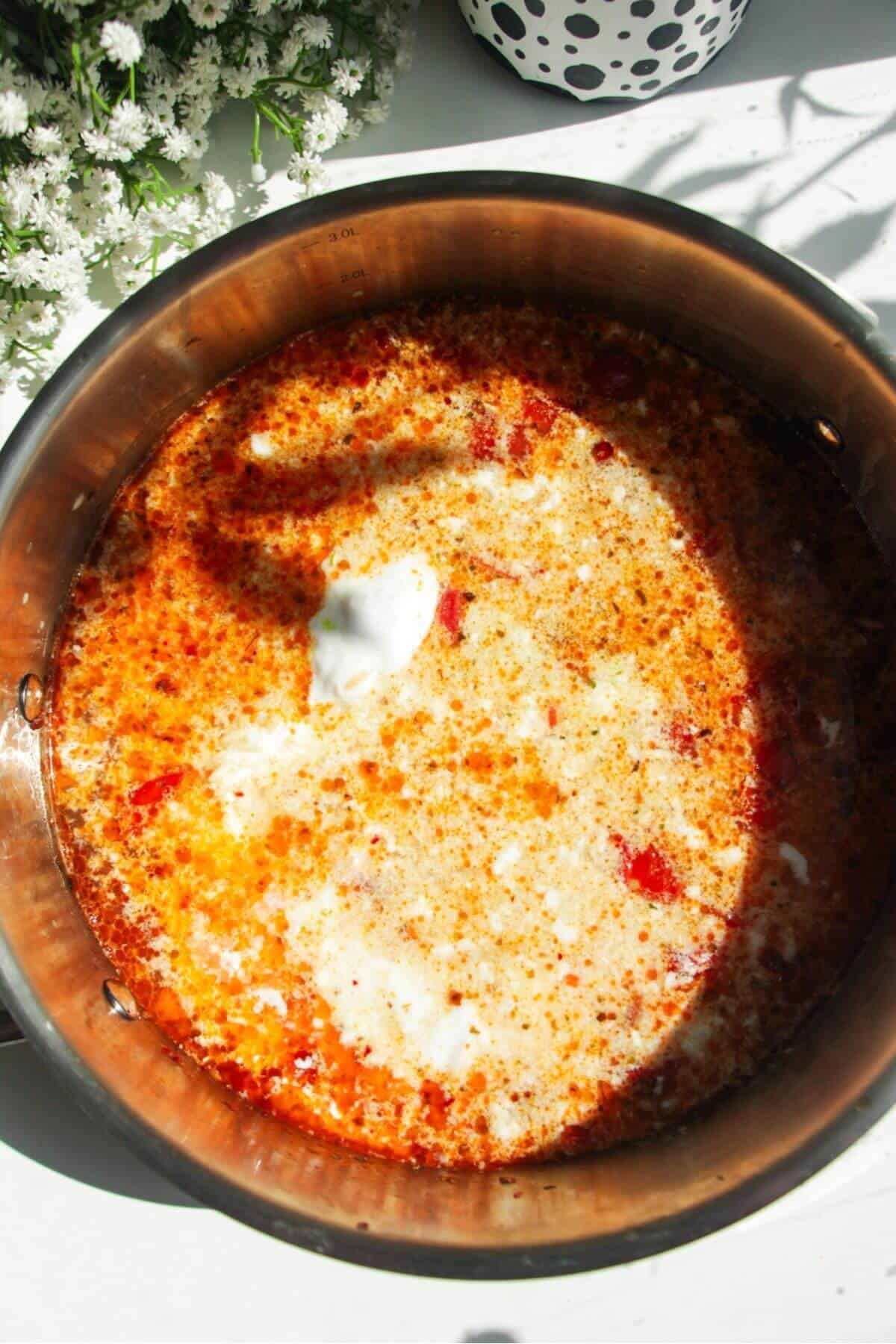 Stock and coconut cream added to orzo in a large pot.