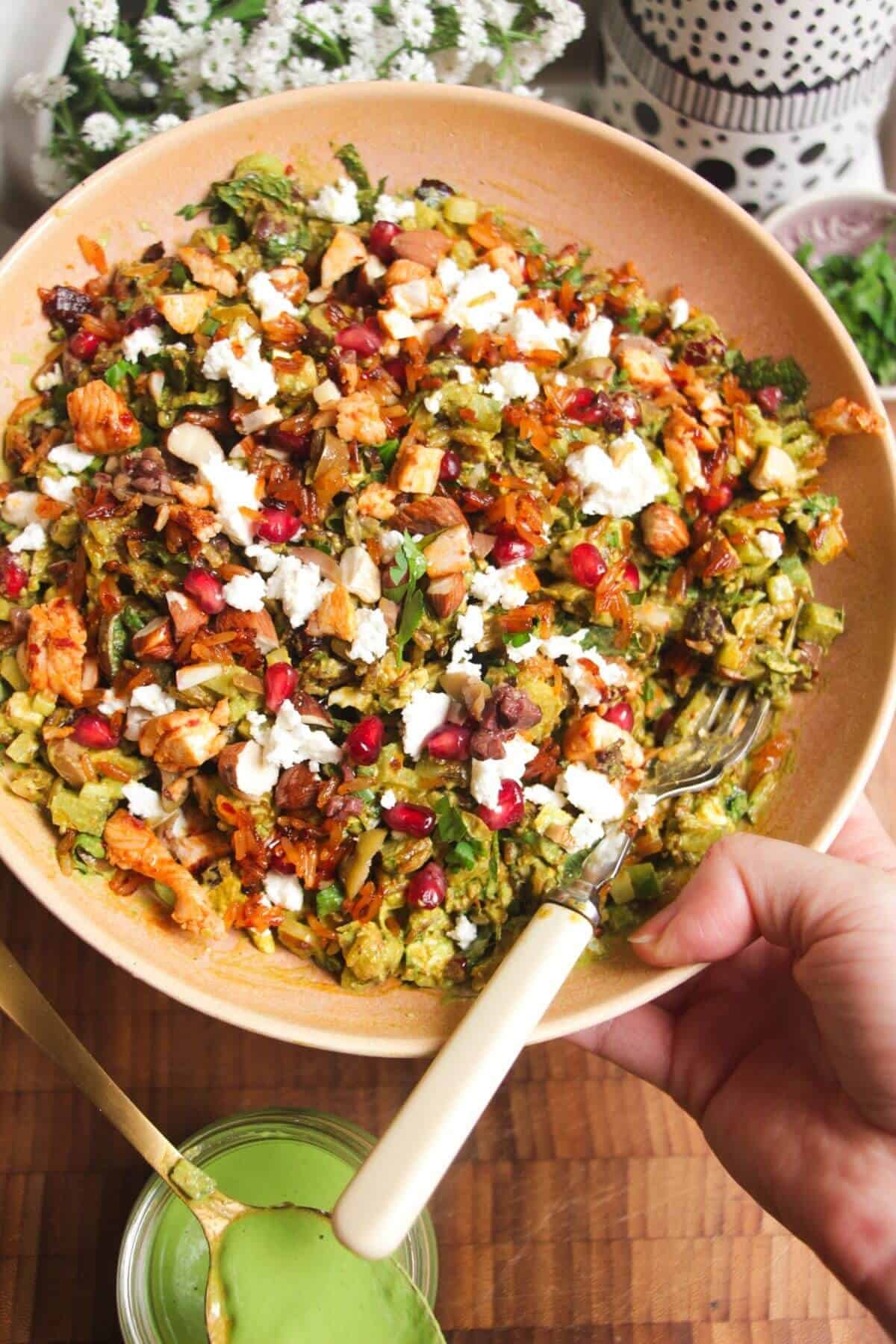 Holding a bowl of Mediterranean crispy rice salad.