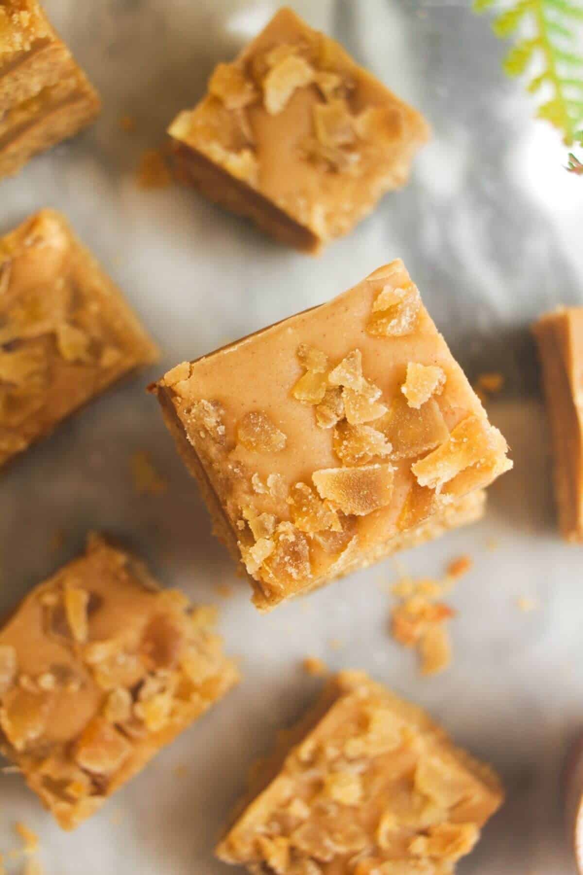 Pile of ginger crunch on top of each other with a coffee cup on the side.