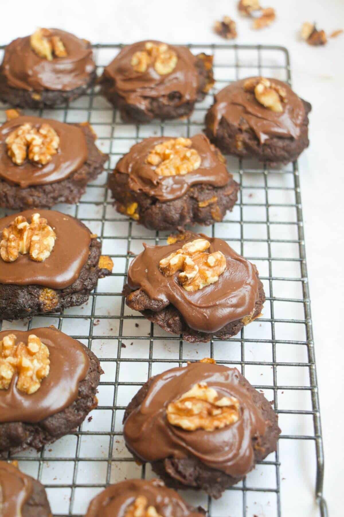 Iced chocolate Afghan biscuits on a wire rack on a white marble background.