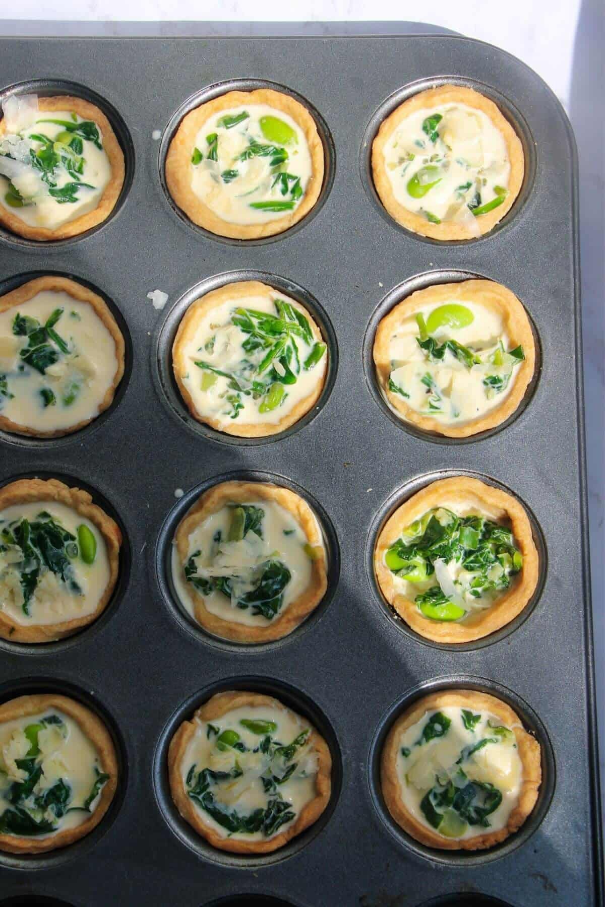 Mini coronation quiches in mini muffin tin, ready to bake.