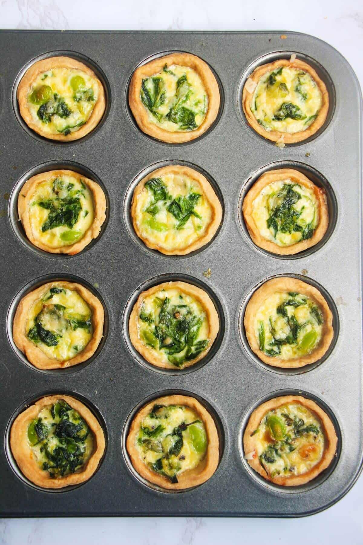 Mini coronation quiches in mini muffin tin after baking.