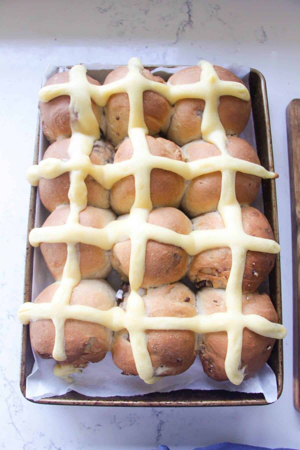 12 mini egg hot cross buns after baking in an oven tray.