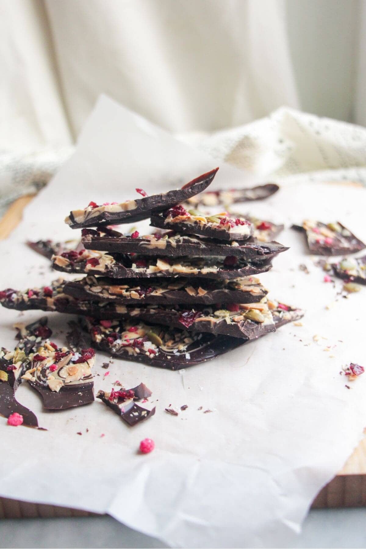 A pile of chocolate almond bark on a baking paper lined board.