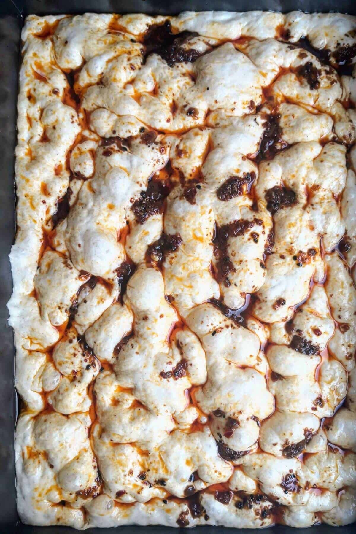 No-knead focaccia with chilli oil on top ready to bake.