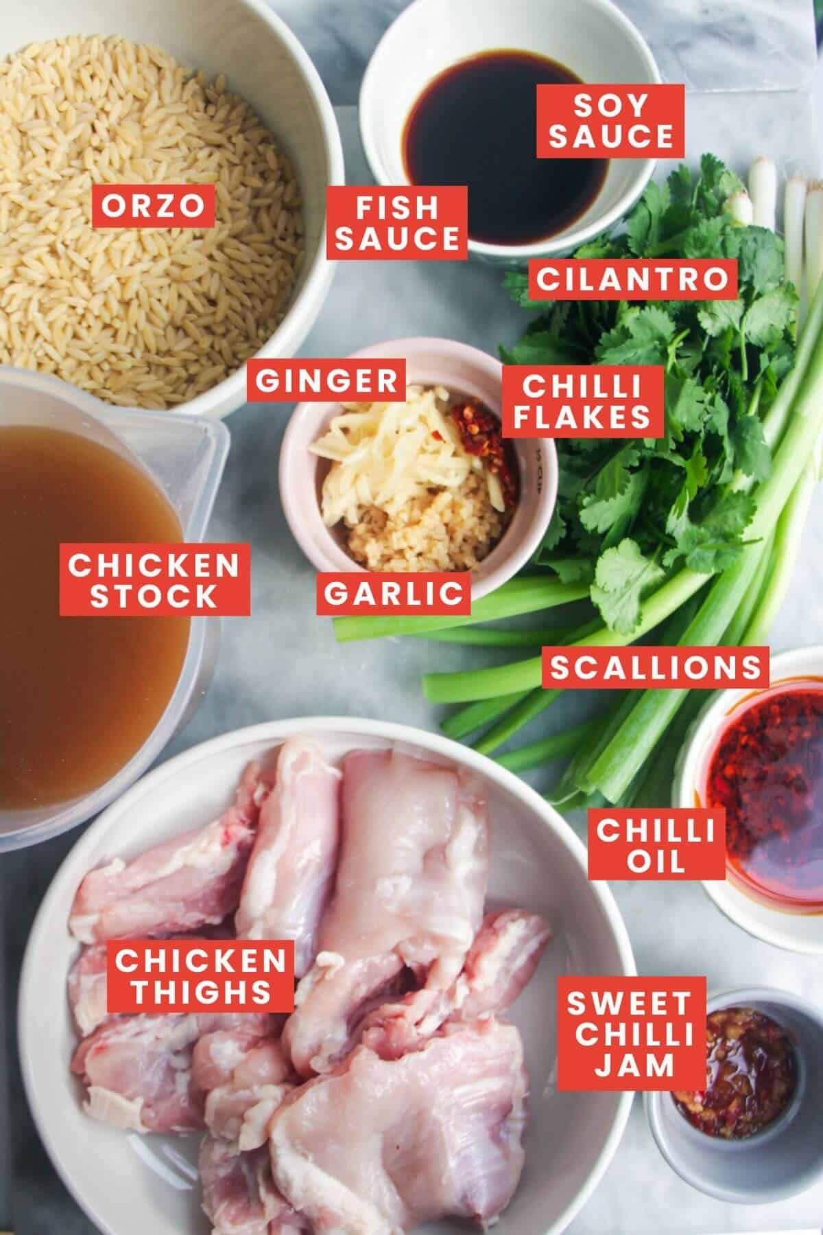 Ingredients for one pot chicken orzo laid out on a grey marble background.