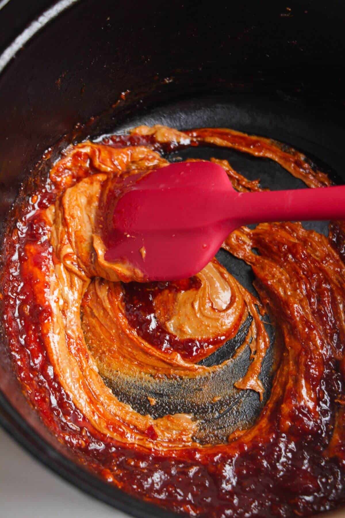 Stirring peanut butter in a large pot.
