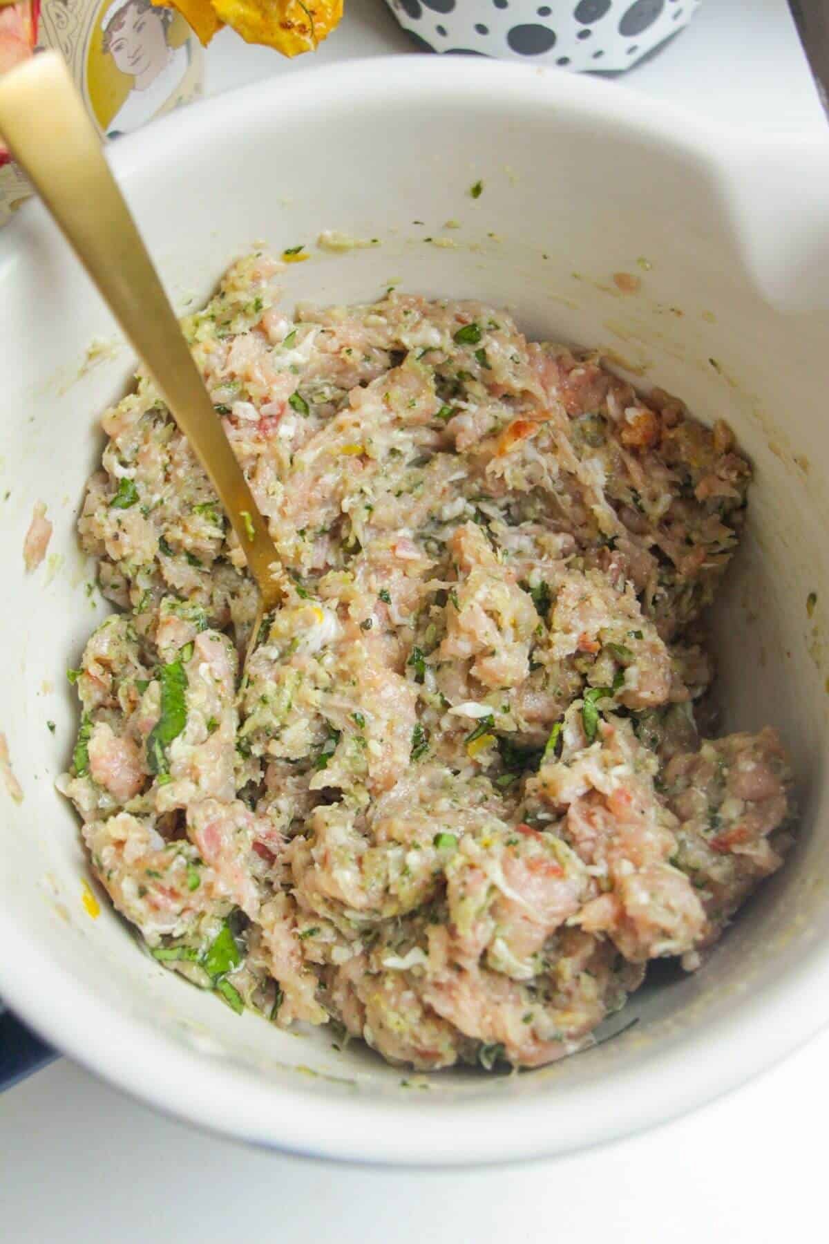 Chicken pesto meatball mixture in a mixing bowl.