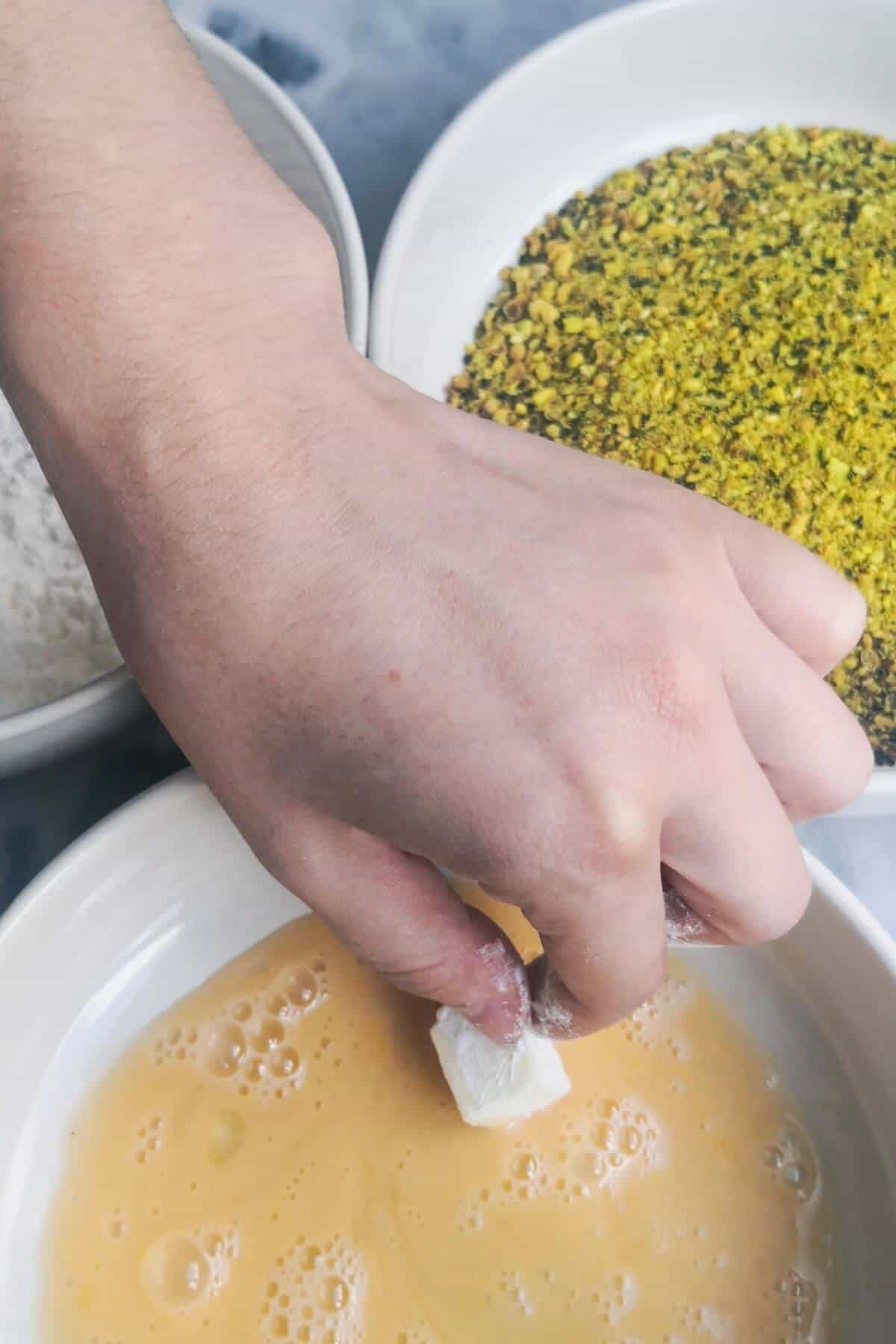 Halloumi bite being dipped in egg.