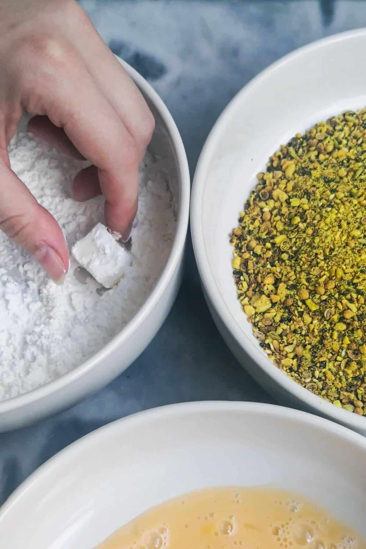 Halloumi bite being dipped in cornflour.