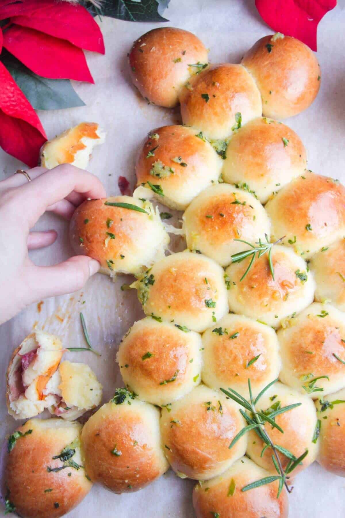 Close up of hand pulling out a dough ball from the Christmas tree.