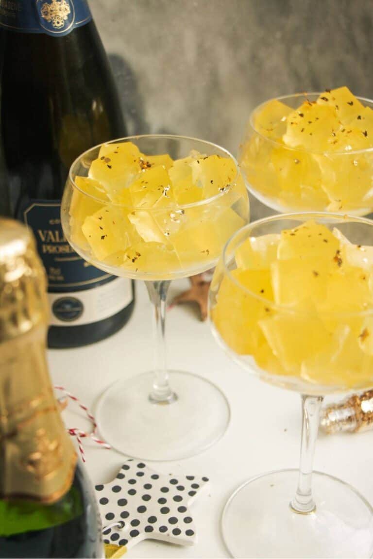 Three champagne coupes filled with jello cubes.