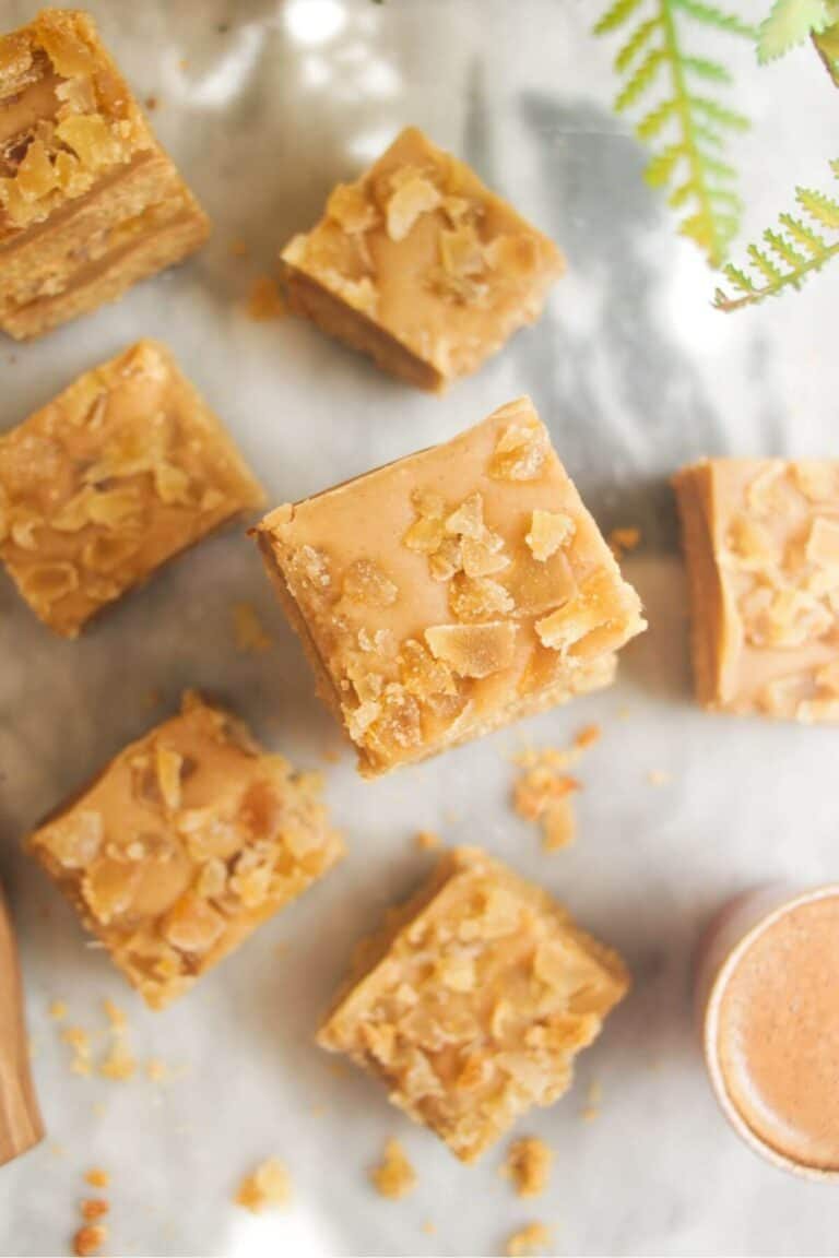 Pile of ginger crunch on top of each other with a coffee cup on the side.