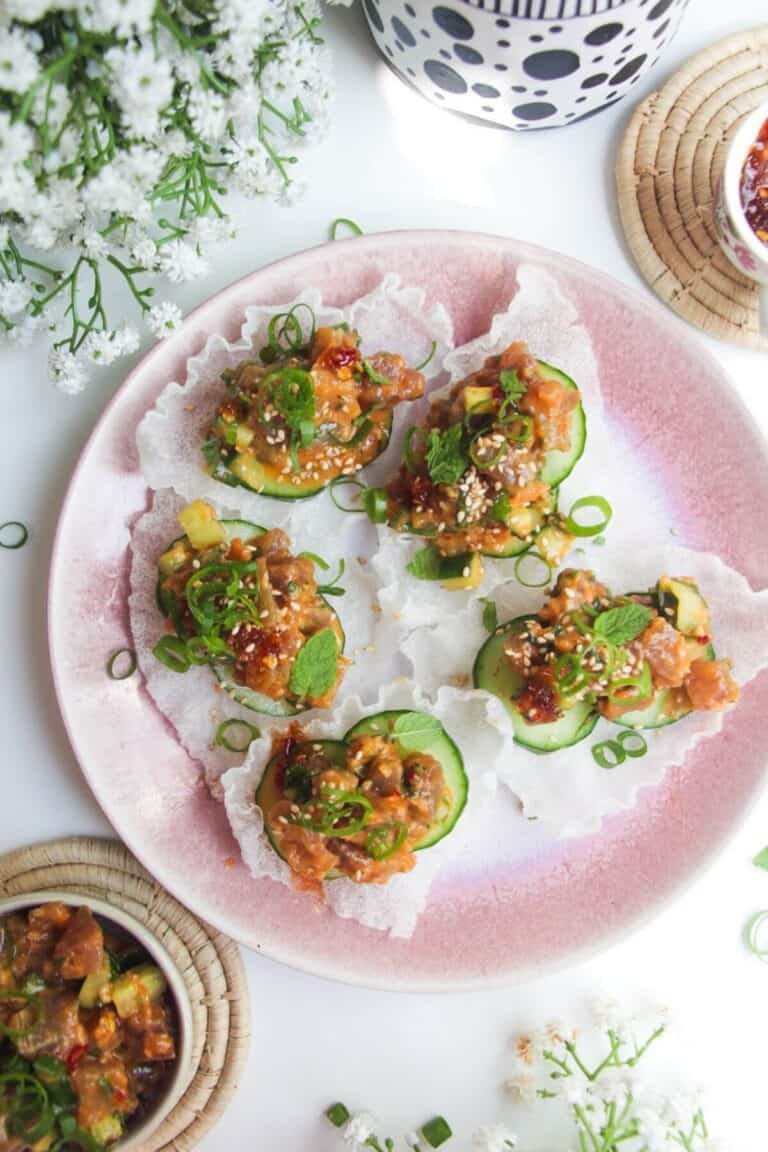Five tuna rice paper cups on a pink plate.