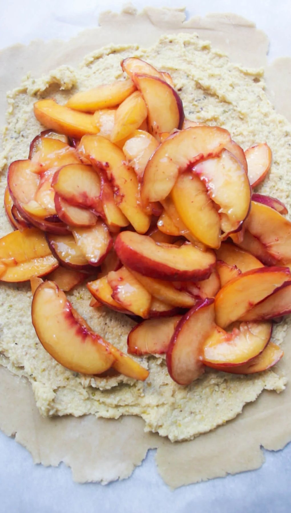 Sliced peaches piled on top of frangipane on pastry.