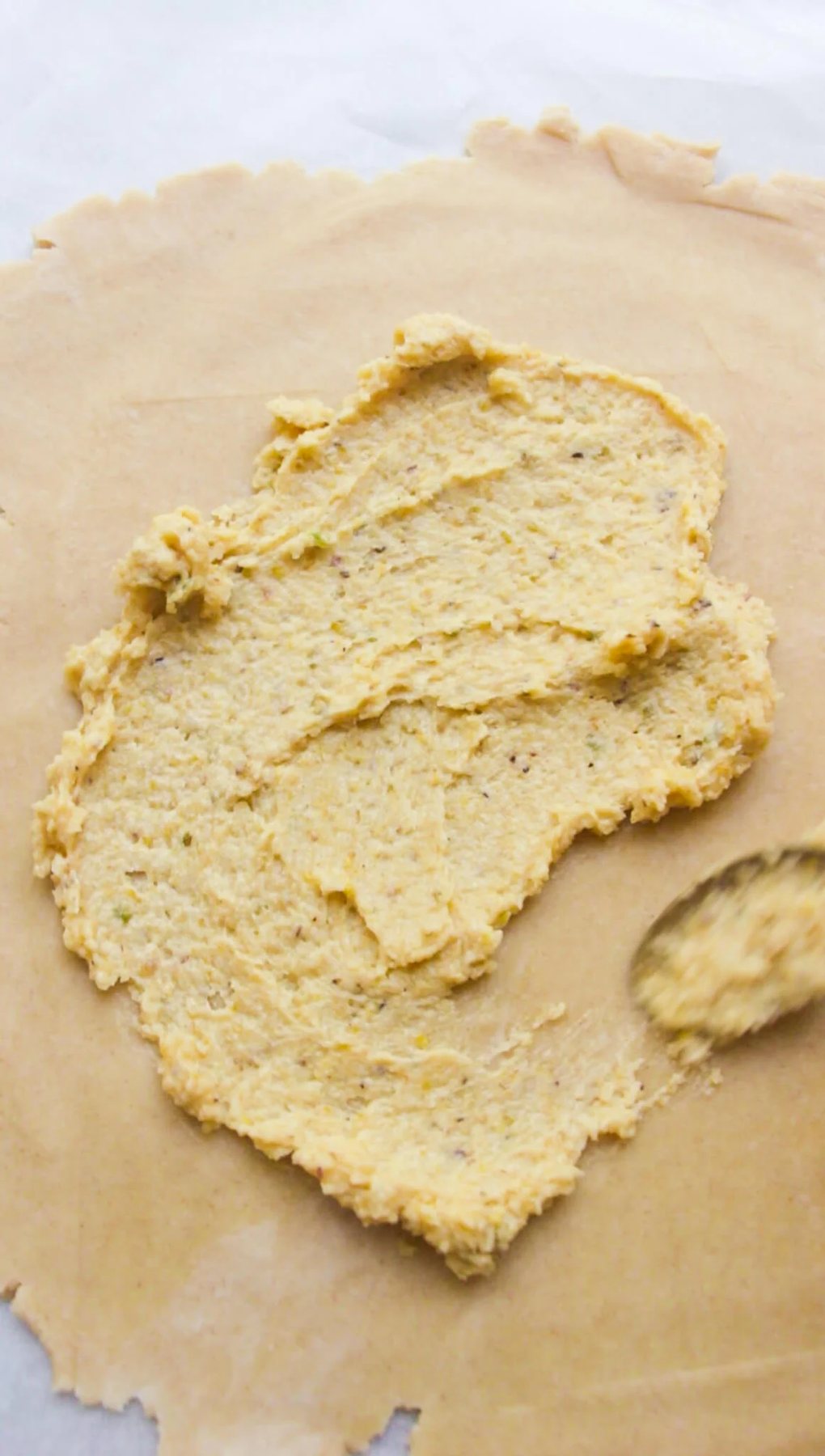 Small spoon smoothing frangipane onto pastry.