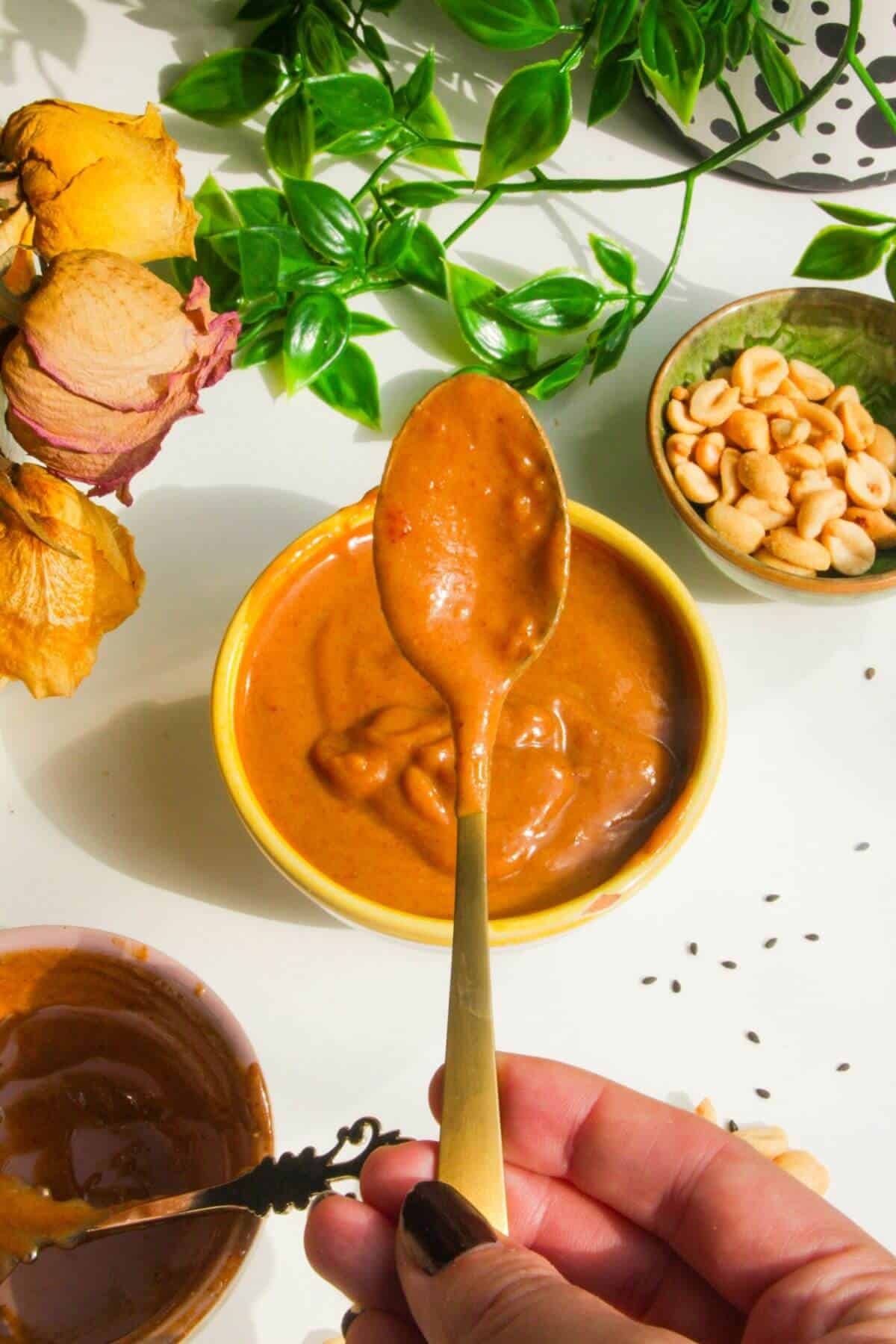 Peanut satay sauce in a small bowl with a spoon.