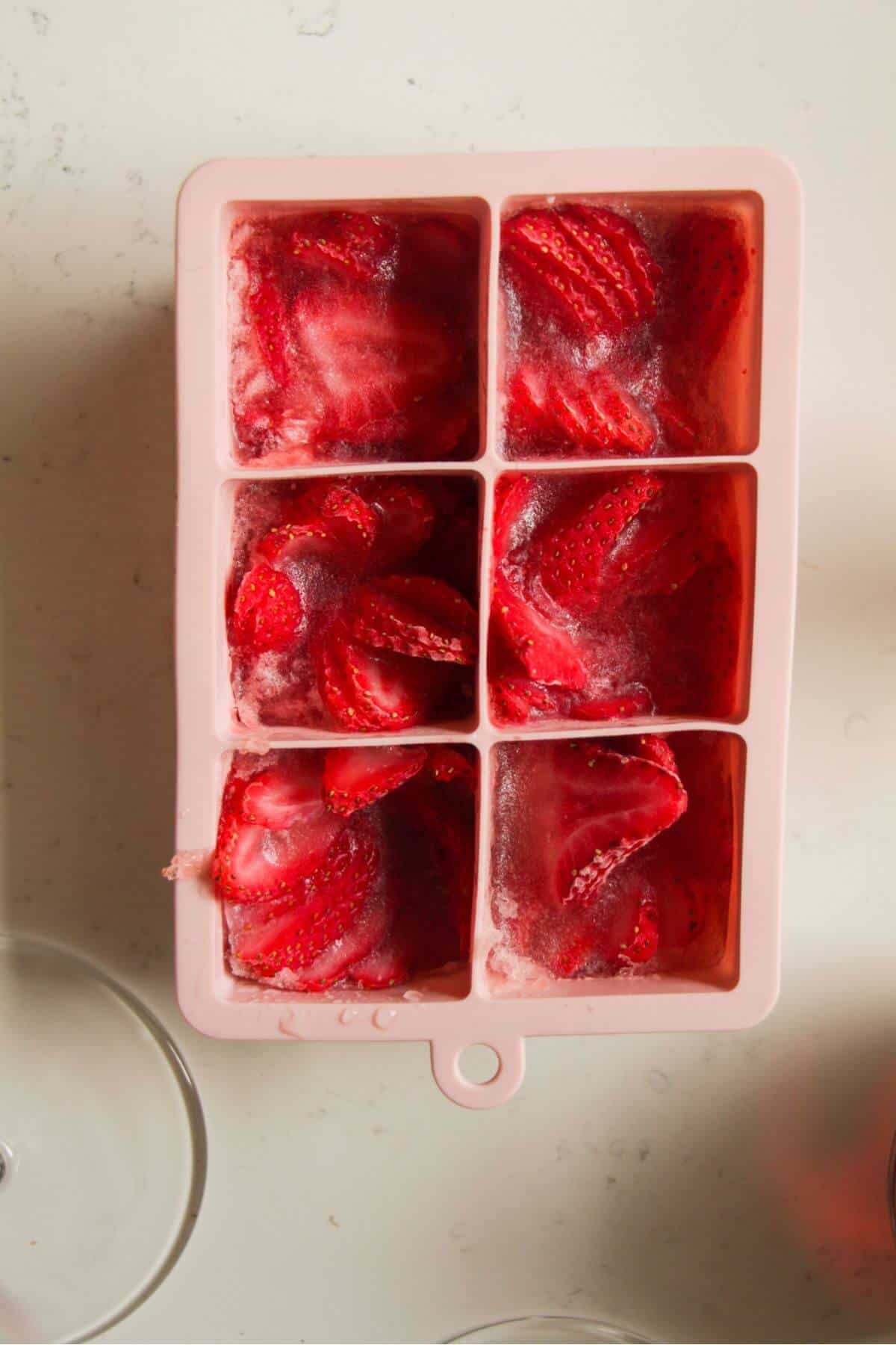 Strawberry rose ice cubes in a pink silicone ice cube tray.