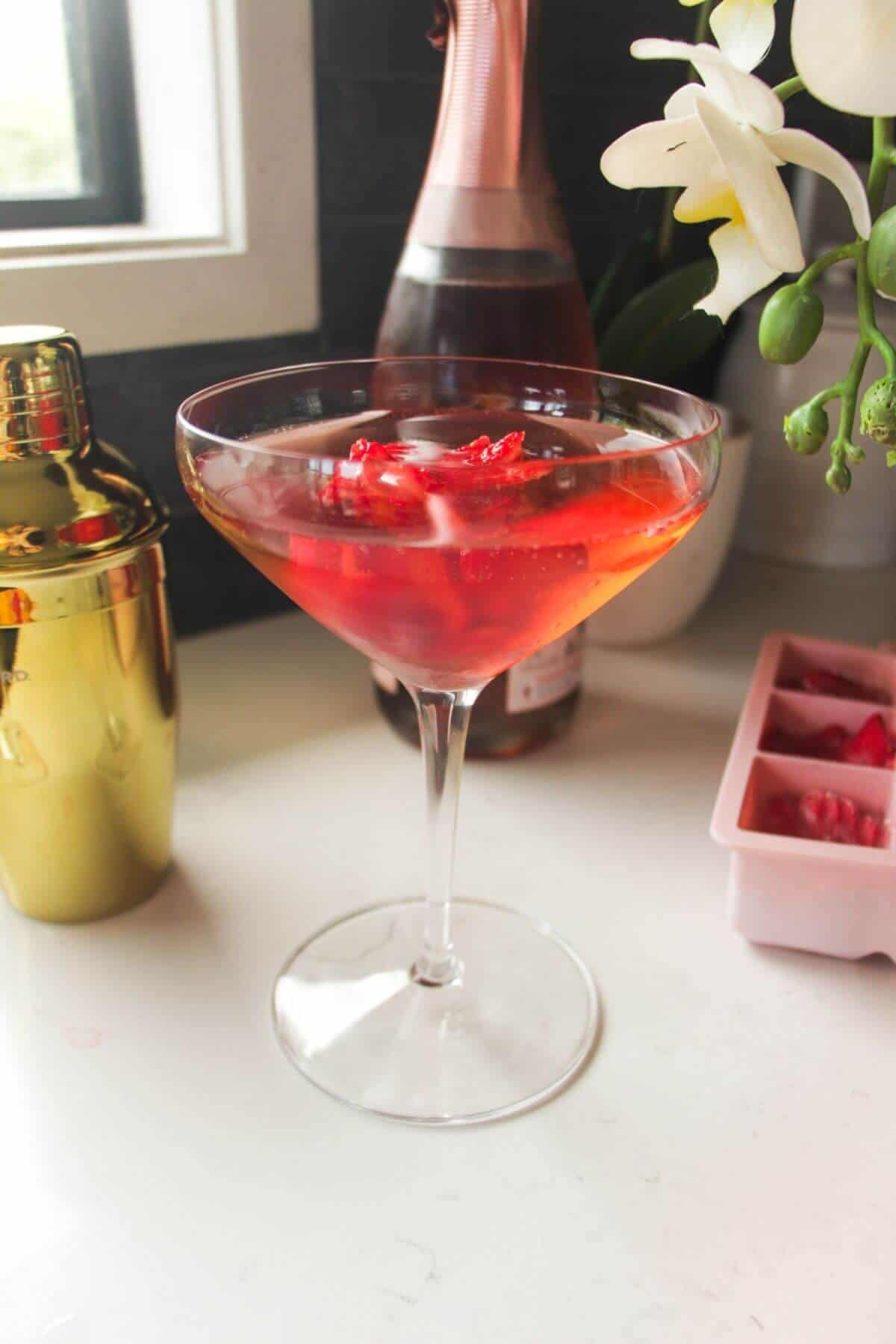 Strawberry rose ice cube in pink gin cocktail.
