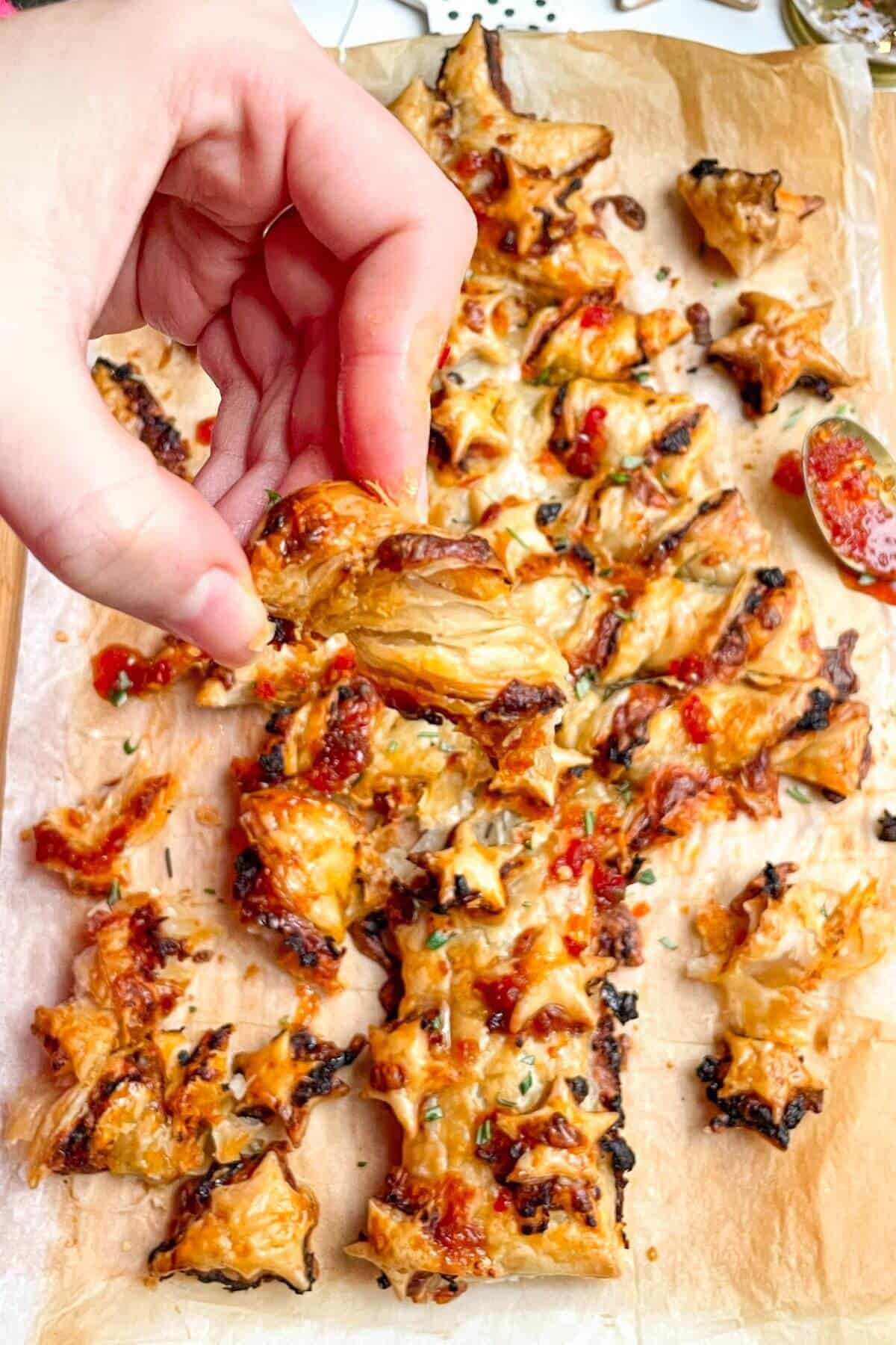 Hand holding up cheesy puff pastry.