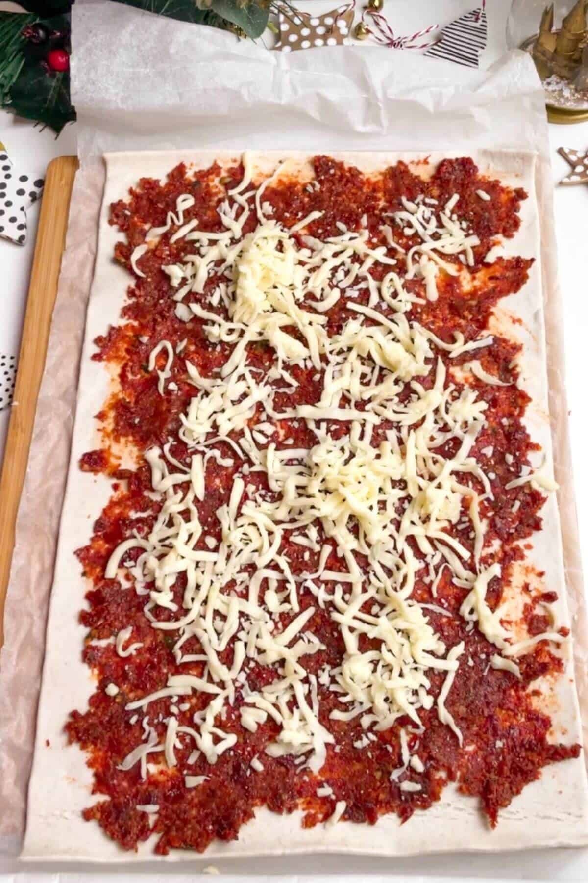 Grated cheese over sundried tomato pesto on a piece of puff pastry.