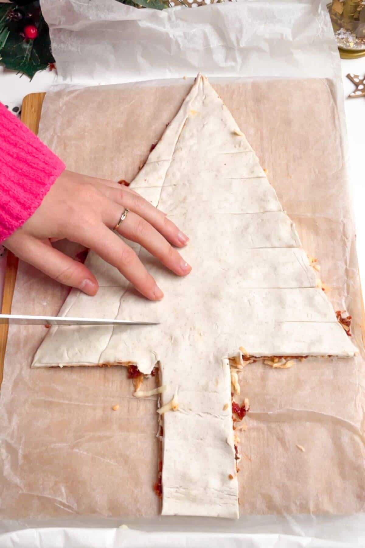 Slicing branches into puff pastry Christmas tree.