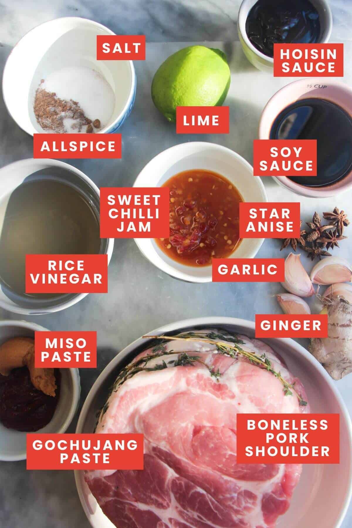 Ingredients for pulled pork laid out on a grey marble background and labelled.