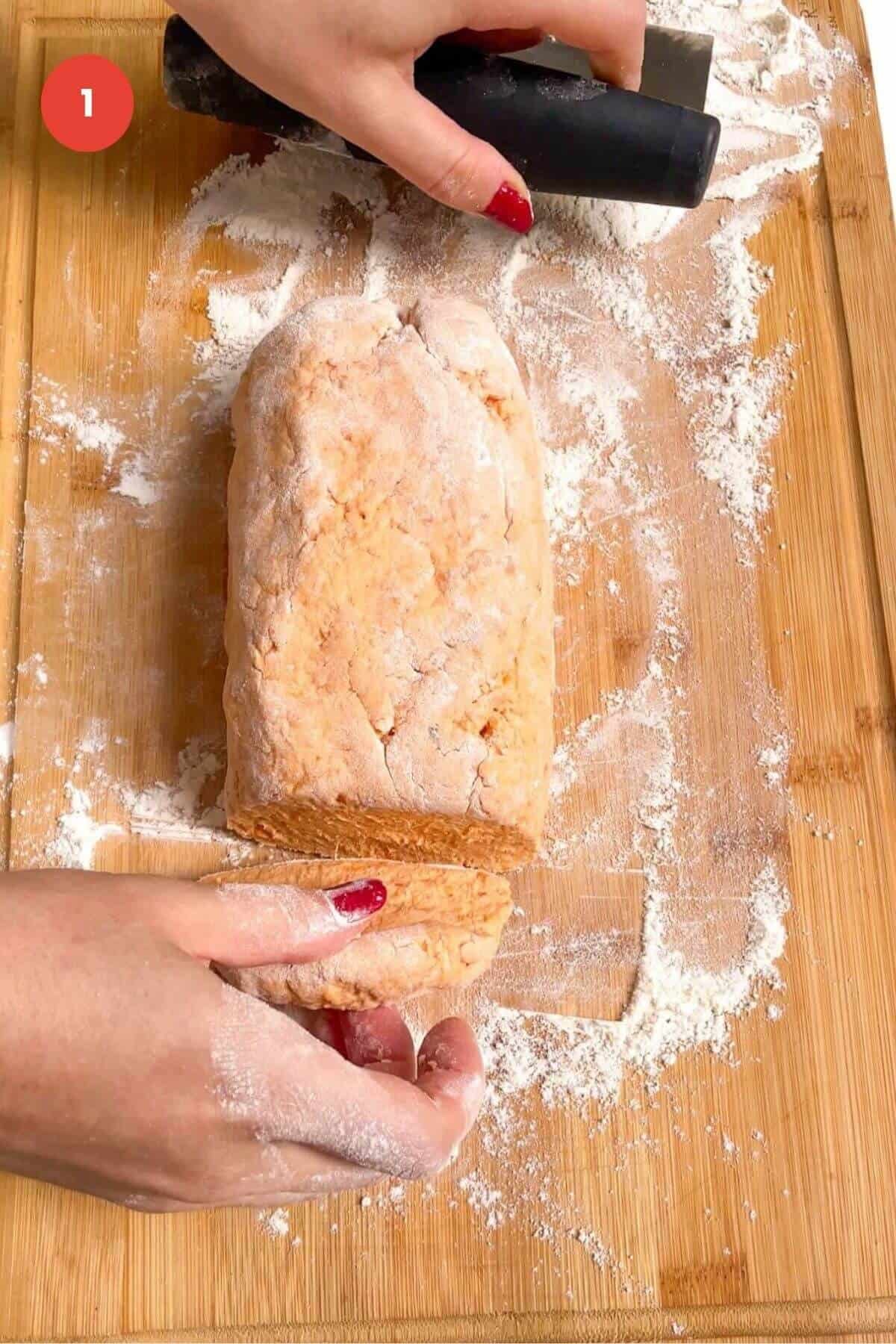 Gnocchi dough cut on wooden board.