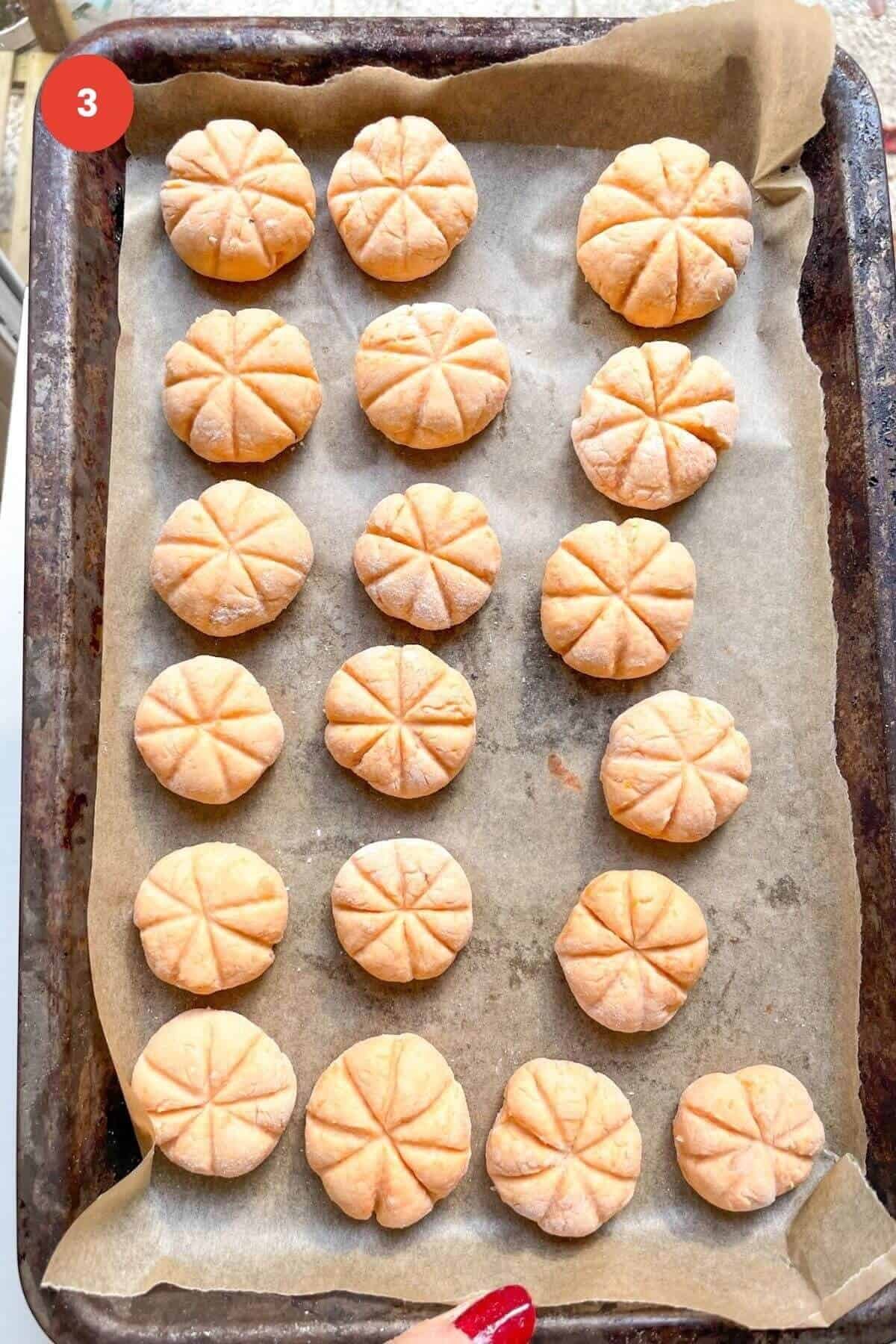 Pumpkin shaped gnocchi on a lined tray.