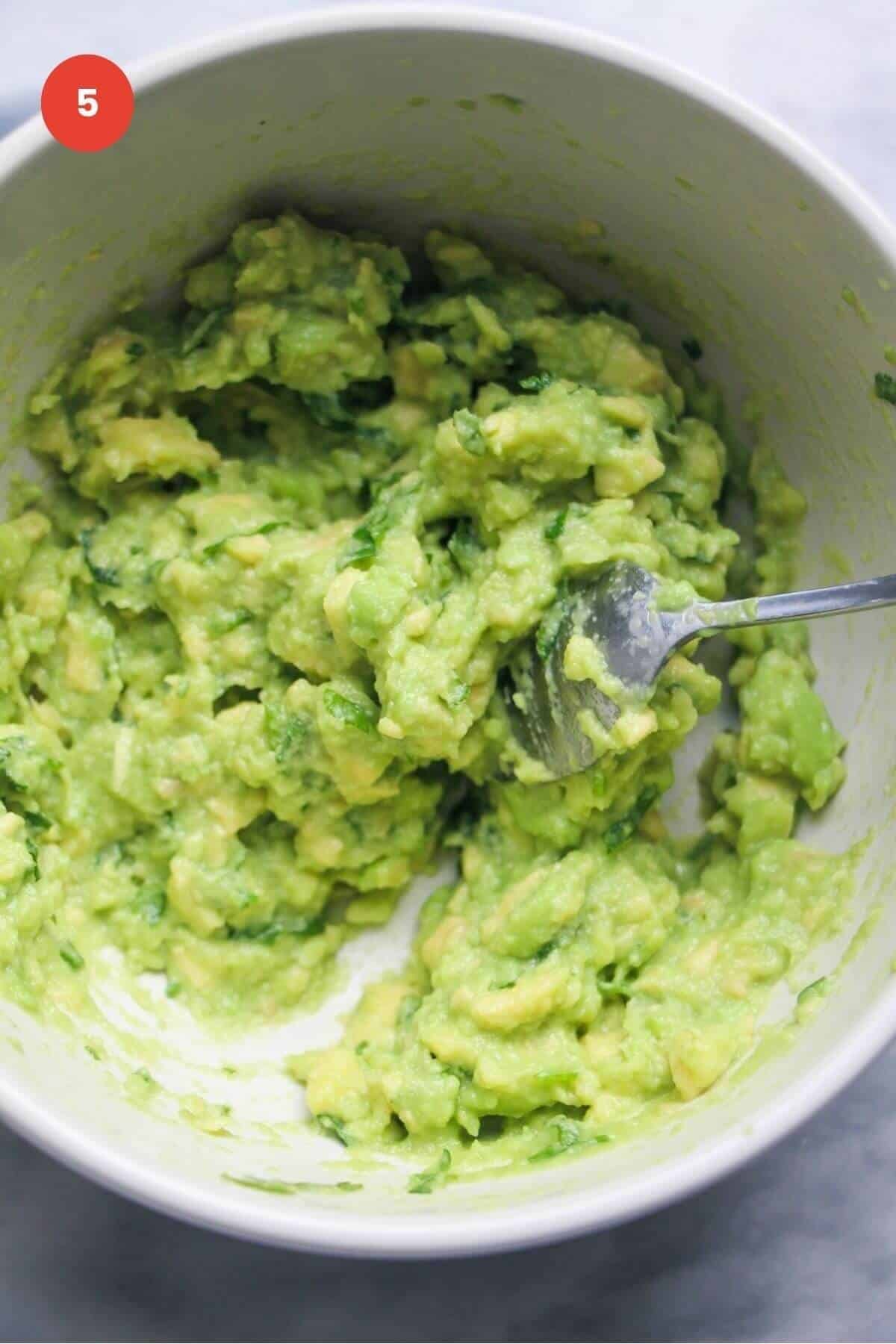 Smashed avocado in a small bowl.
