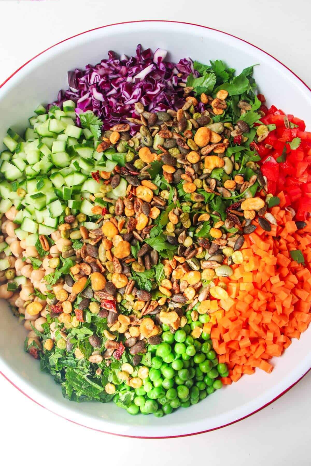 Rainbow chopped salad ingredients in a large white bowl.
