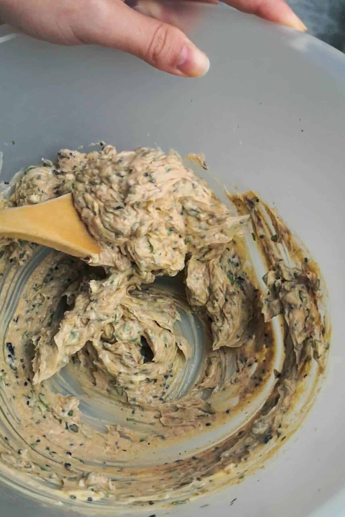 Roasted garlic butter mixed together in a large mixing bowl with a wooden spoon.
