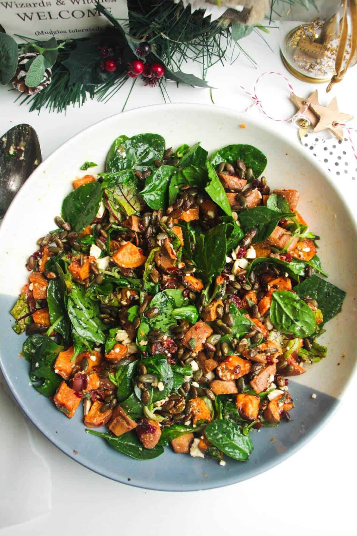 Roasted sweet potato salad in a large white and blue bowl.