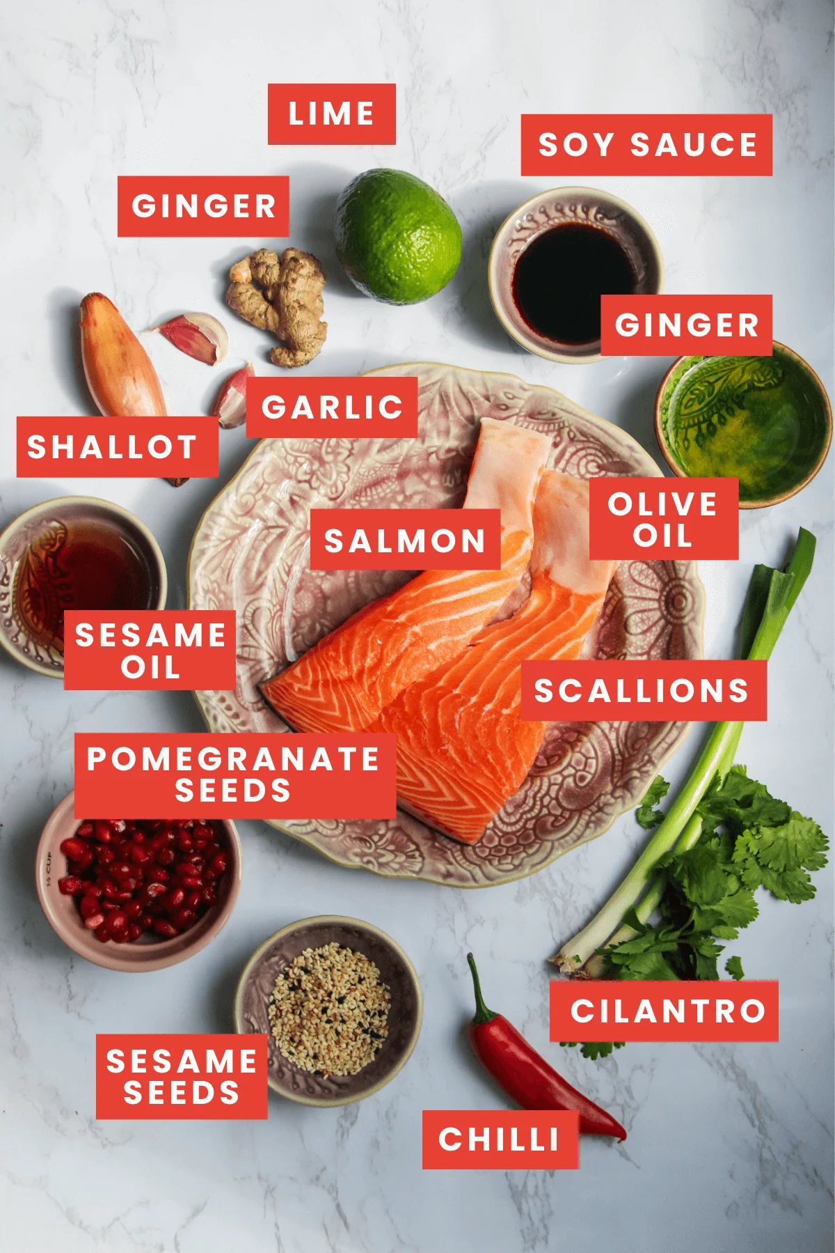 Salmon crudo ingredients laid out on a white marble background.
