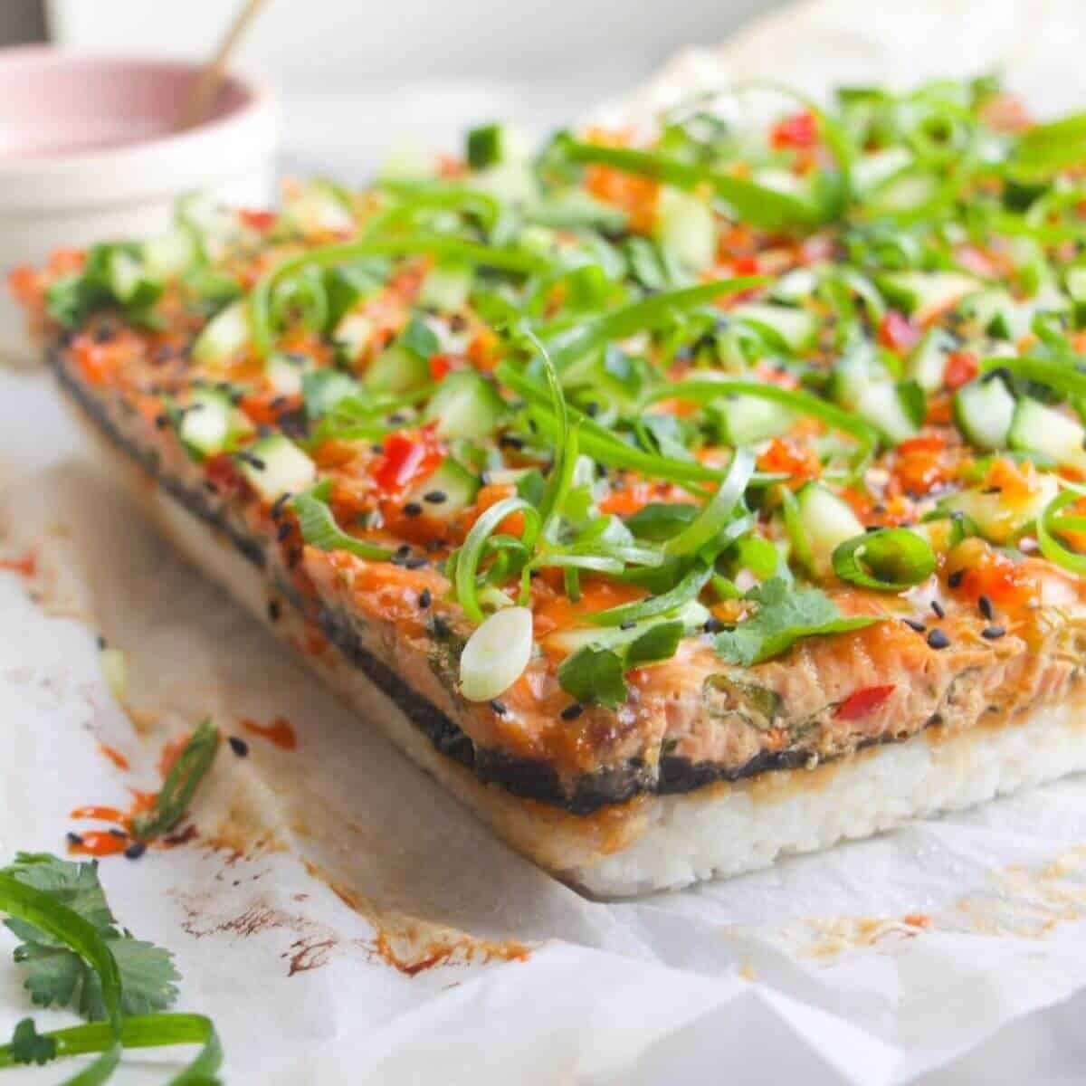 Salmon sushi bake on a baking paper lined tray.