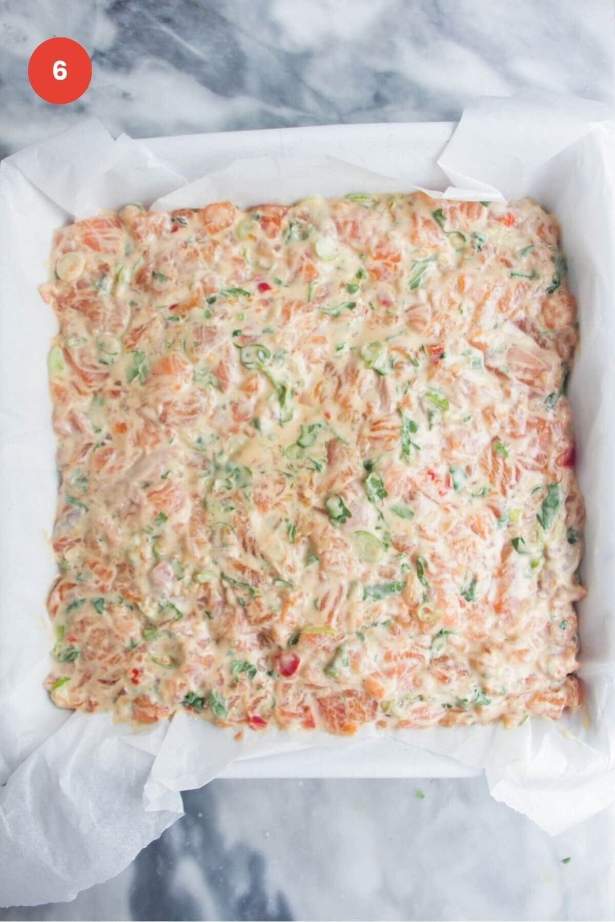 Salmon mixture smoothed onto nori sheet in a baking dish.