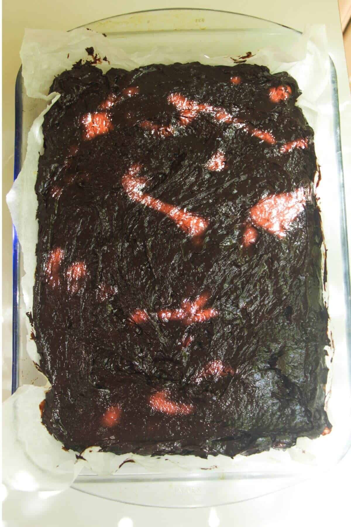 Brownie in a lined oven dish ready to be baked.