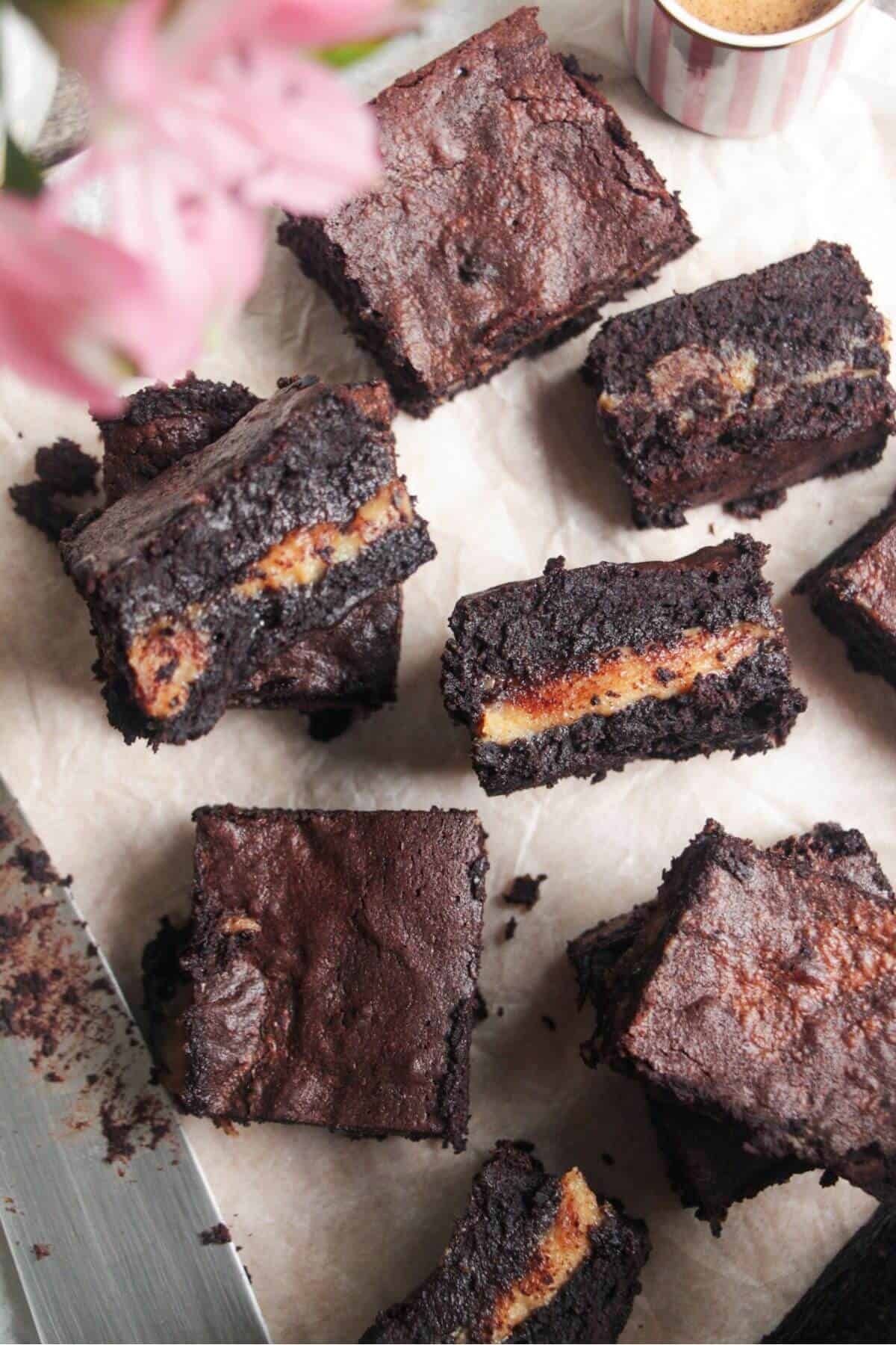 Sliced salted caramel brownies on baking paper.