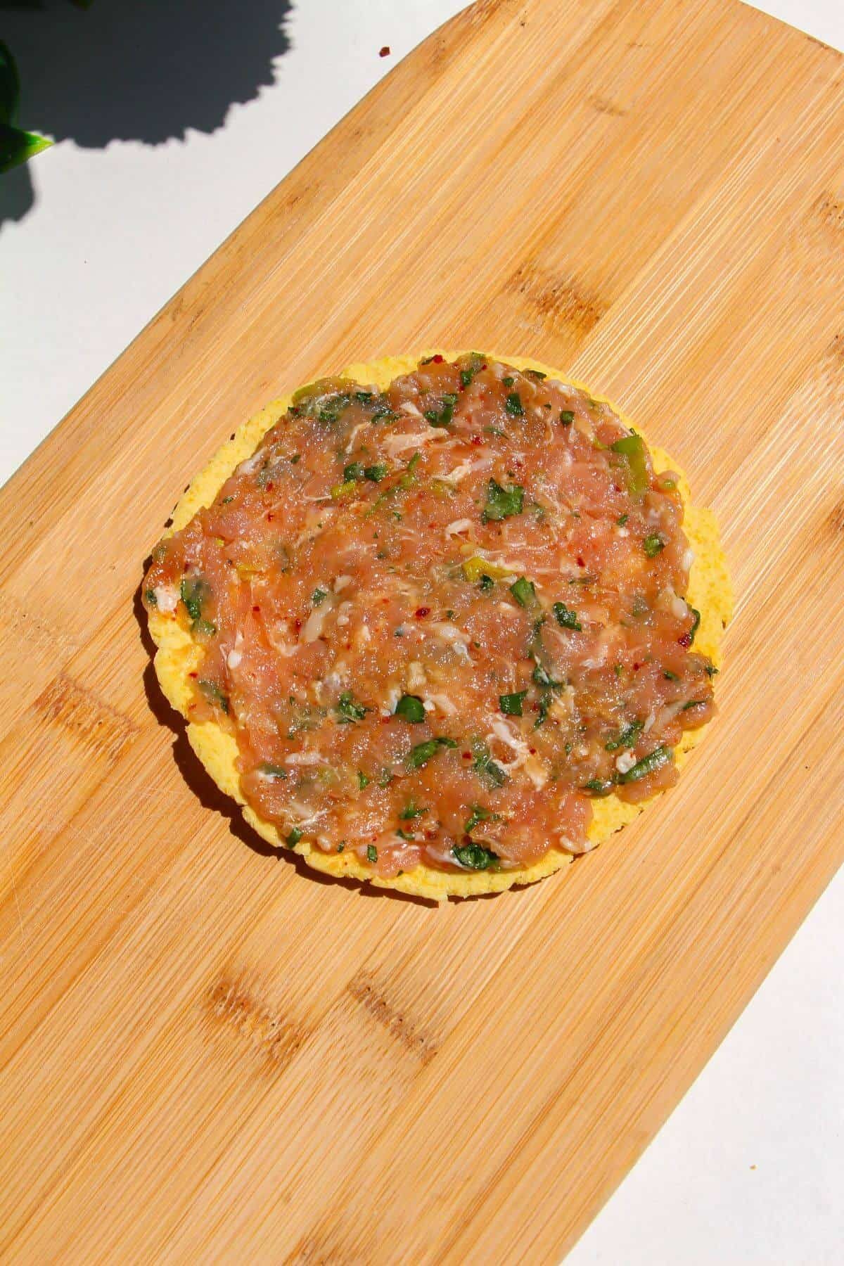 Chicken mixture spread onto mini tortilla.