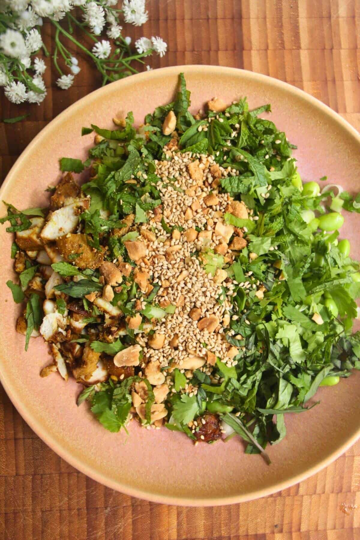 Crispy rice salad ingredients in pink bowl.