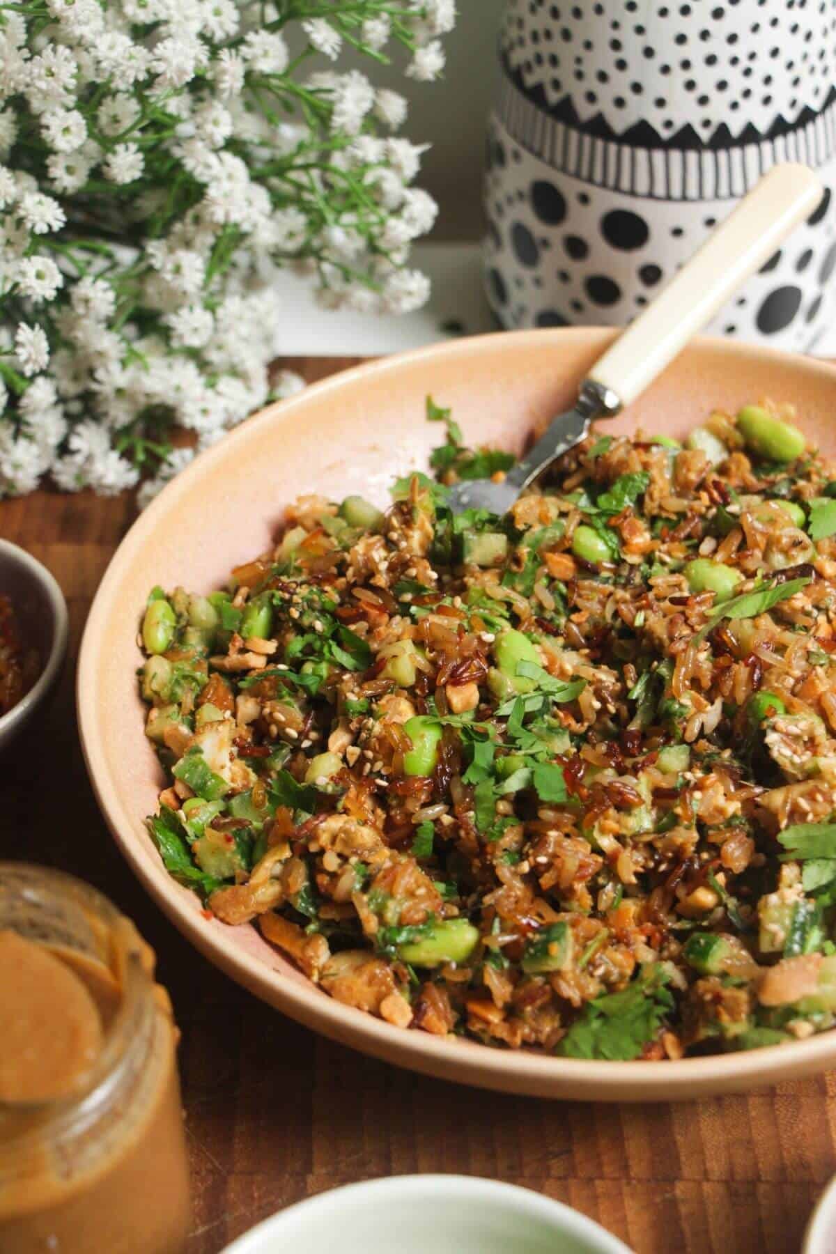 Crispy rice salad mixed in a pink bowl.
