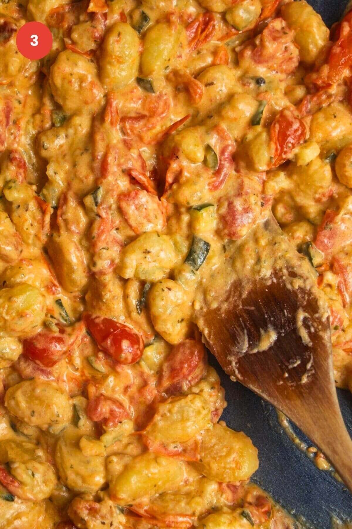 Gnocchi mixed through tomato Boursin sauce in baking dish.
