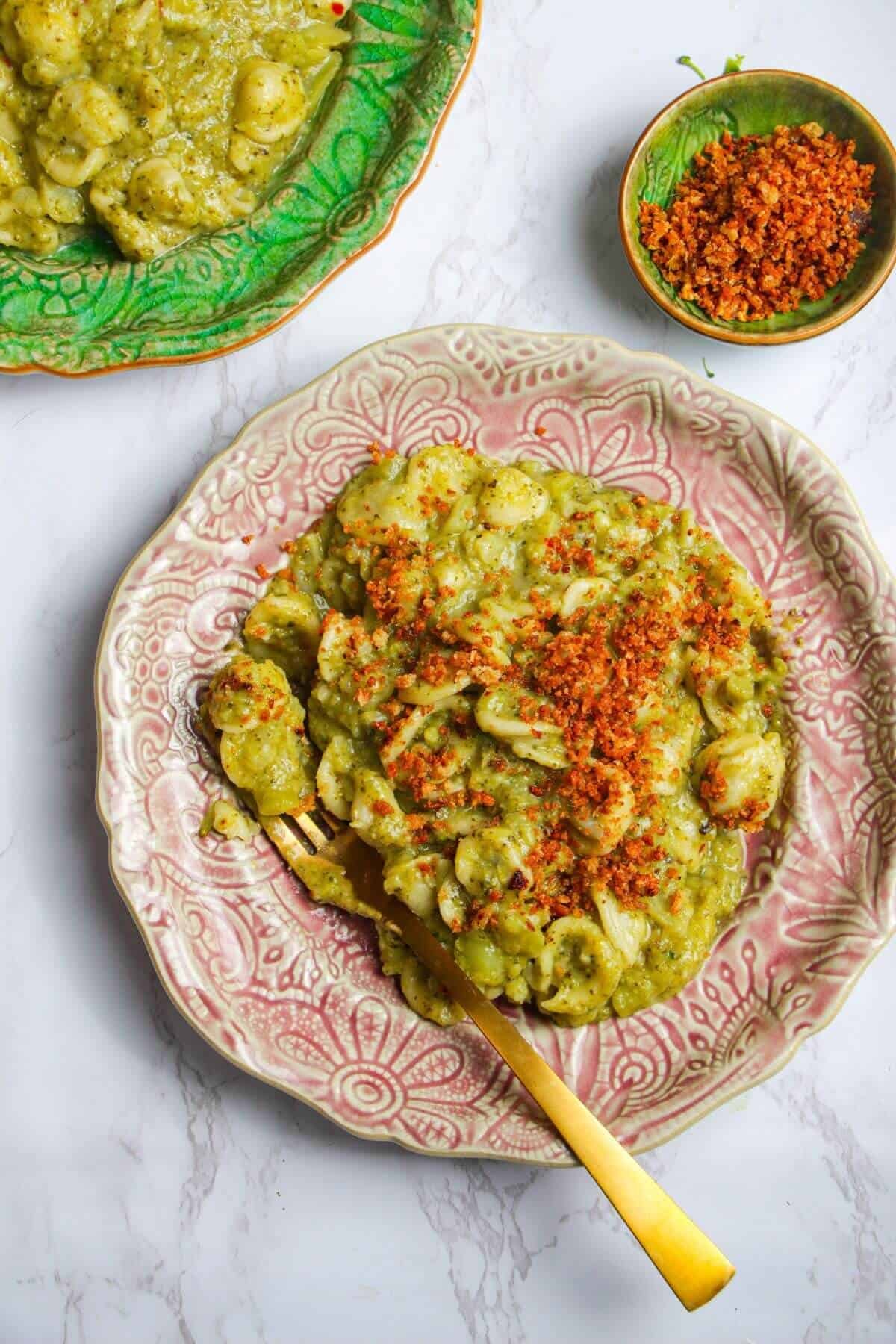 Broccoli pasta topped with golden pangrattato on a plate.